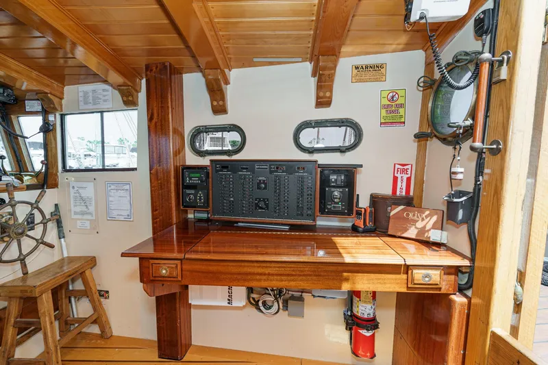 Slide: The Image of 1938 Norwegian Double Ended Ketch interior with wooden helm, control panel, and safety equipment. - 55