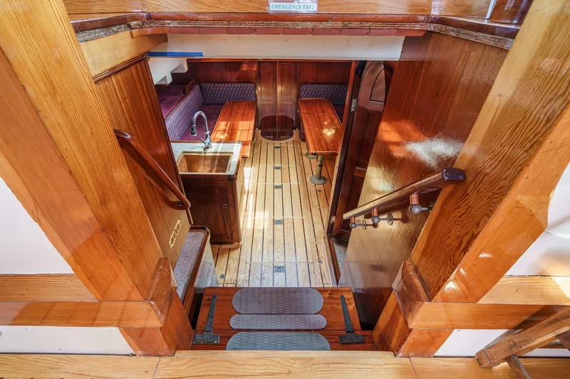 Slide: The Image of Interior of 1938 Norwegian Double Ended Ketch, featuring wooden finishes and cozy seating area. - 65