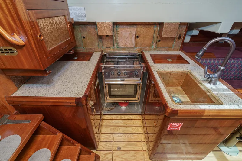 Slide: The Image of Vintage 1938 Norwegian Double Ended Ketch galley with wood cabinetry and compact stove. - 68