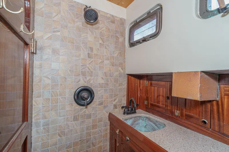 Slide: The Image of 1938 Norwegian Double Ended Ketch bathroom with tiled shower and wooden cabinetry. - 72