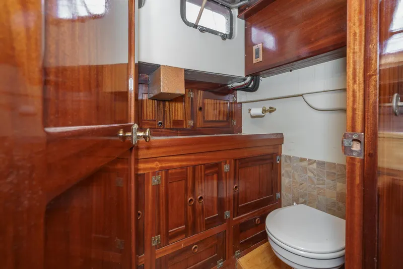 Slide: The Image of Wood-paneled bathroom in a 1938 Norwegian Double Ended Ketch, featuring a compact toilet. - 73