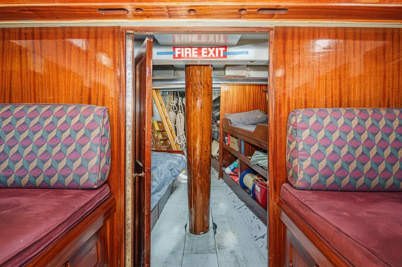 Slide: The Image of Interior of 1938 Norwegian Double Ended Ketch with wooden finish and fire exit sign. - 76