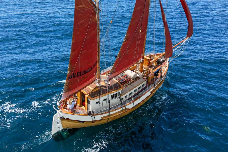 Slide: The Image of 1938 Norwegian Double Ended Ketch sailing on open blue sea with red sails. - 8