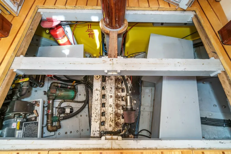 Slide: The Image of Engine room of 1938 Norwegian Double Ended Ketch, featuring mechanical components and fire extinguisher. - 84
