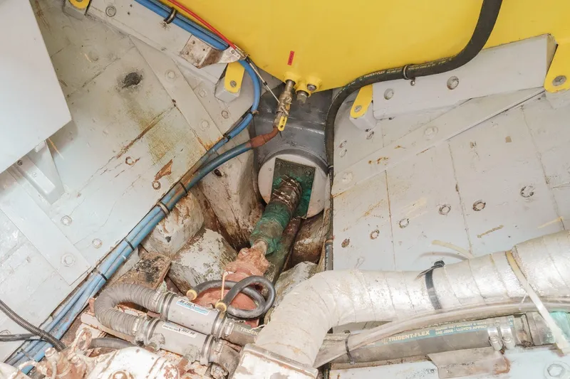 Slide: The Image of Engine room of a 1938 Norwegian Double Ended Ketch, showing pipes and mechanical components. - 89