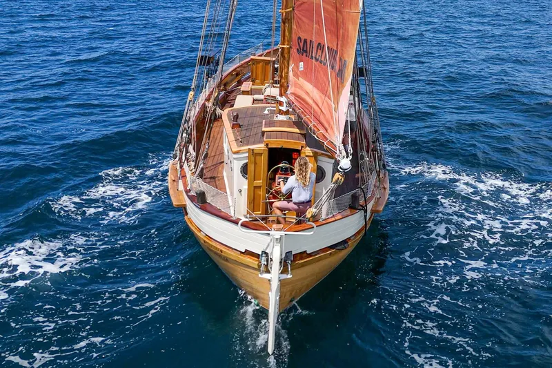 Slide: The Image of 1938 Norwegian Double Ended Ketch sailing on open sea with vibrant red sails. - 9