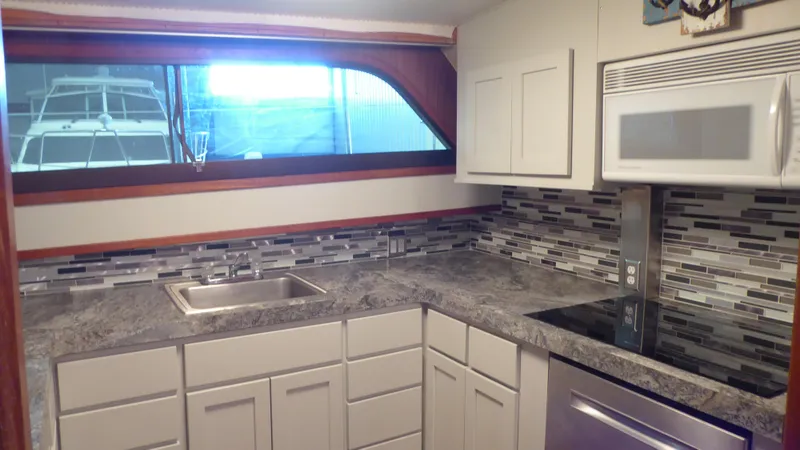 Slide: The Image of Modern kitchen interior of 1985 Hatteras 56 Motor Yacht with sleek countertops and appliances. - 12