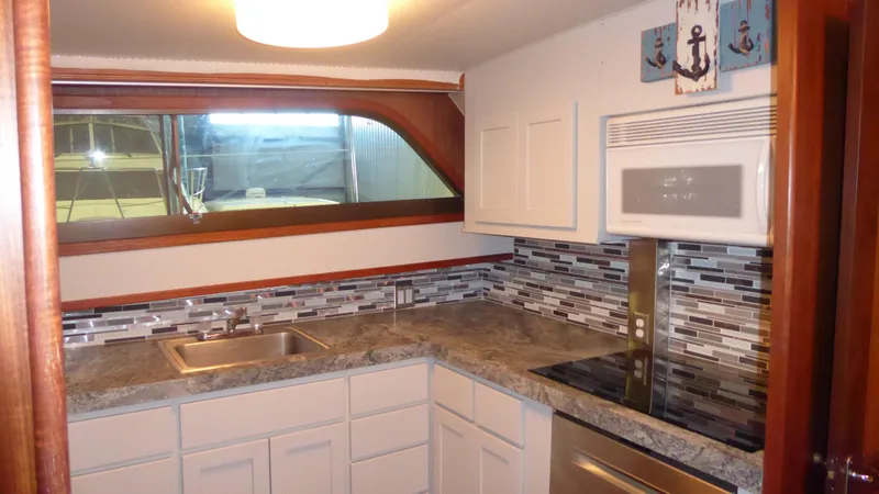 Slide: The Image of 1985 Hatteras 56 Motor Yacht kitchen with modern appliances and stylish backsplash. - 14