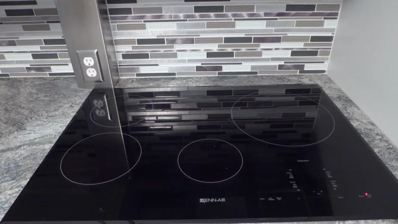 Slide: The Image of Modern kitchen cooktop with sleek black design and stylish tile backsplash on a Hatteras 56 Motor Yacht. - 18