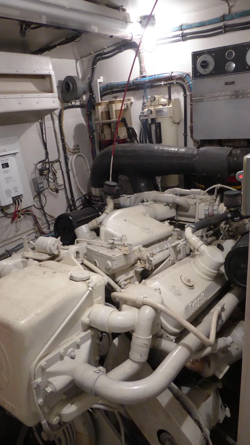 Slide: The Image of Engine room of a 1985 Hatteras 56 Motor Yacht, showcasing mechanical components and wiring. - 26