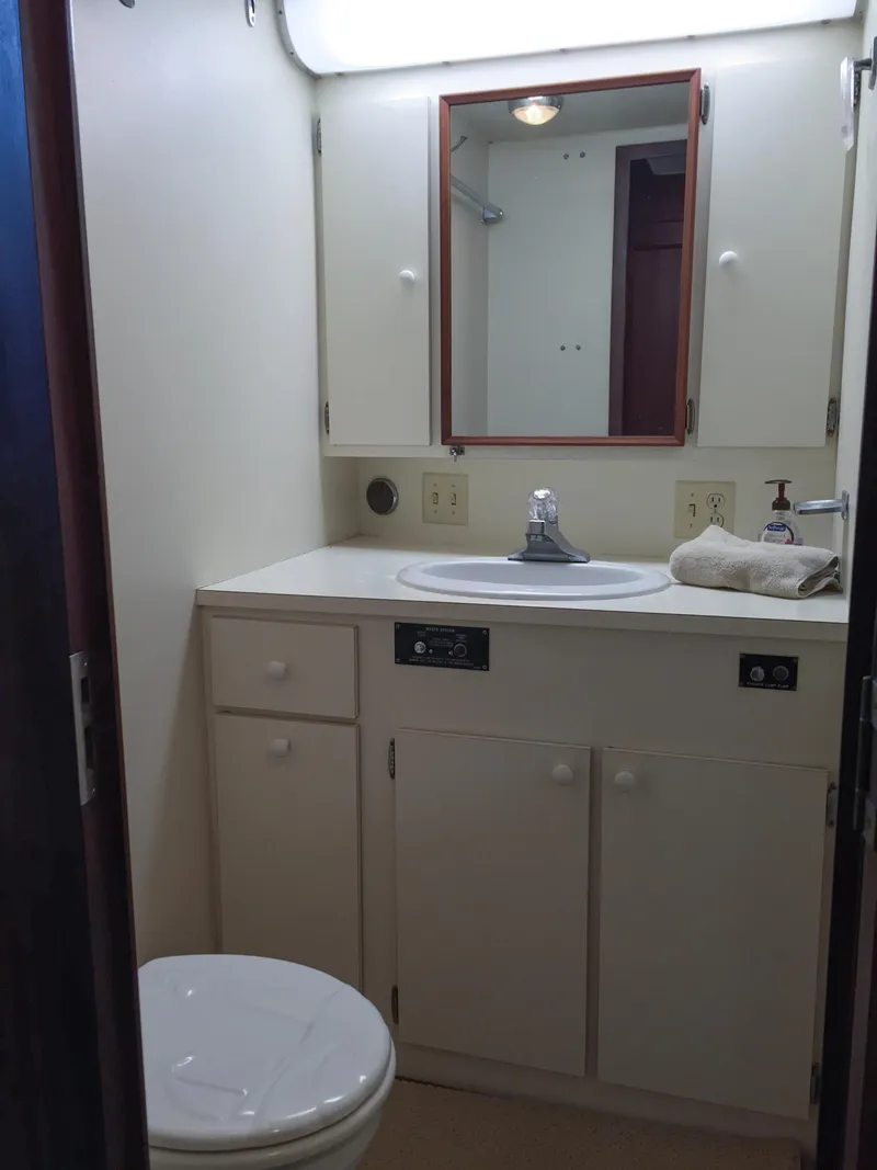 Slide: The Image of 1985 Hatteras 56 Motor Yacht bathroom with sink, mirror, and toilet. - 31