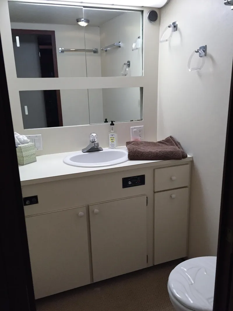 Slide: The Image of 1985 Hatteras 56 Motor Yacht bathroom with sink, mirror, and storage cabinets. - 32