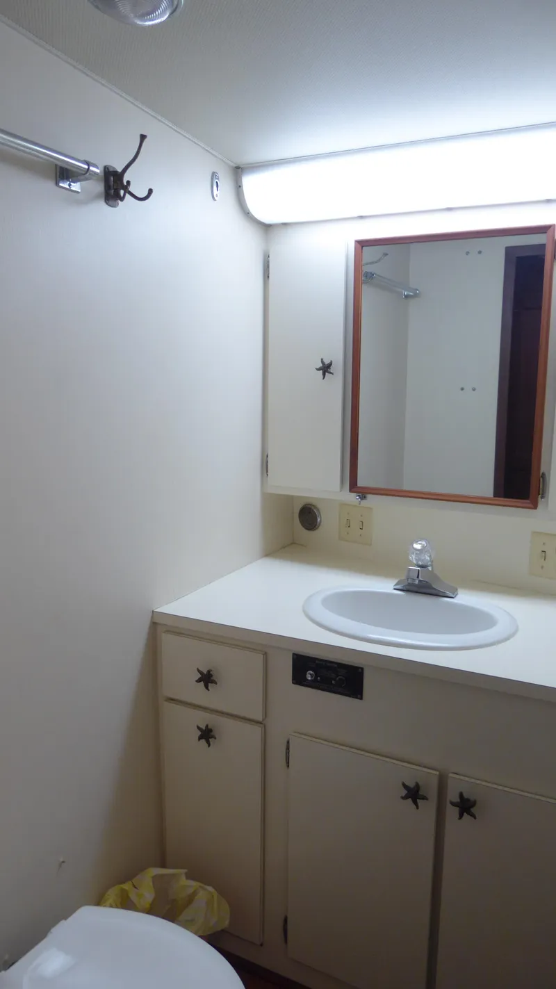 Slide: The Image of 1985 Hatteras 56 Motor Yacht bathroom with sink, mirror, and storage cabinets. - 33