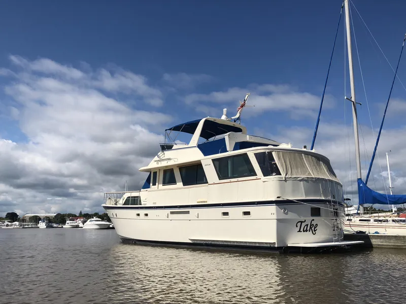 Slide: The Image of 1985 Hatteras 56 Motor Yacht docked under a partly cloudy sky. - 5