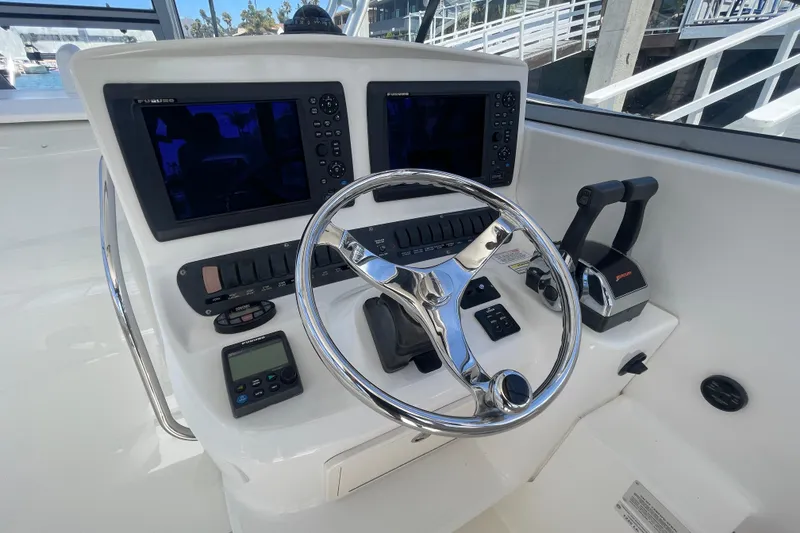 Slide: The Image of 2004 Boston Whaler 305 Conquest helm with dual screens and chrome steering wheel. - 15