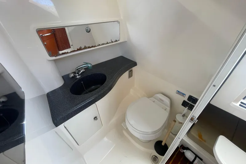 Slide: The Image of 2004 Boston Whaler 305 Conquest bathroom with sink, mirror, and toilet. - 23