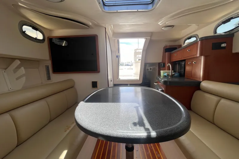 Slide: The Image of Interior of 2004 Boston Whaler 305 Conquest, featuring seating and kitchenette. - 25