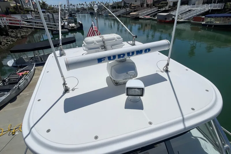 Slide: The Image of 2004 Boston Whaler 305 Conquest boat docked in a marina, featuring radar equipment. - 3