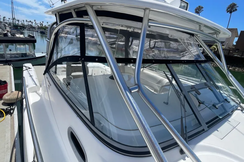 Slide: The Image of 2004 Boston Whaler 305 Conquest boat docked in marina, clear skies, palm trees. - 4