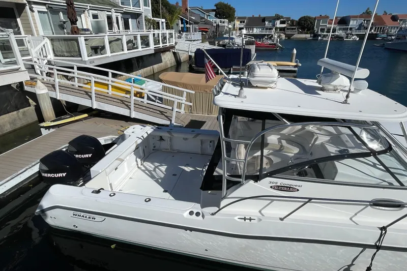Slide: The Image of 2004 Boston Whaler 305 Conquest docked with dual Mercury engines. - 40