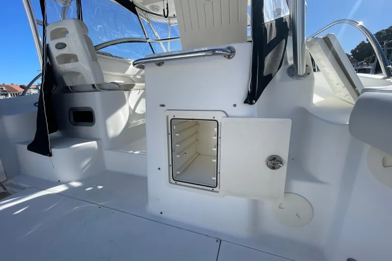 Slide: The Image of 2004 Boston Whaler 305 Conquest interior with open storage compartment and seating. - 46