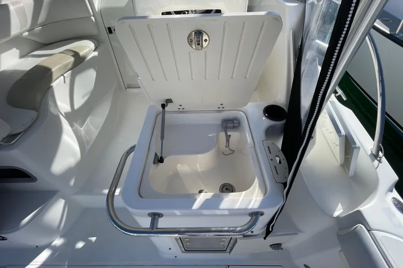 Slide: The Image of 2004 Boston Whaler 305 Conquest interior with open storage compartment and seating area. - 47