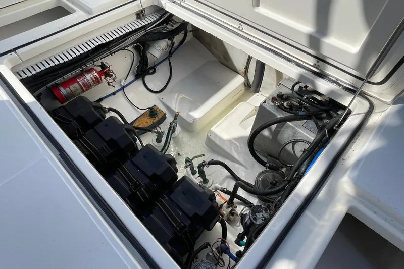 Slide: The Image of 2004 Boston Whaler 305 Conquest engine compartment with batteries and fire extinguisher. - 50