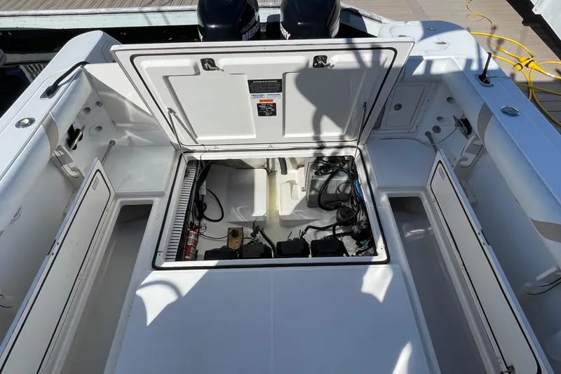 Slide: The Image of 2004 Boston Whaler 305 Conquest boat engine compartment with open hatches and visible equipment. - 51