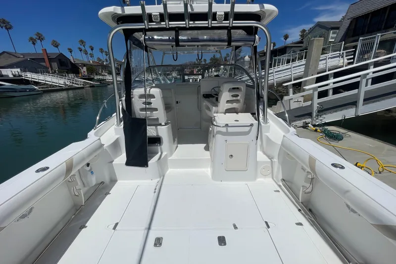 Slide: The Image of 2004 Boston Whaler 305 Conquest boat docked, showcasing spacious deck and seating area. - 9