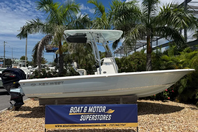 The Image of 2025 Key West 230 Bay Reef boat displayed at Boat & Motor Superstores, surrounded by palm trees. - 0