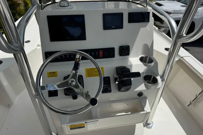 Slide: The Image of 2025 Key West 230 Bay Reef boat console with steering wheel and navigation controls. - 14