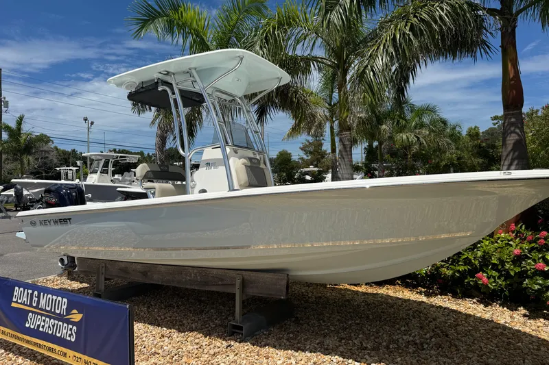 Slide: The Image of 2025 Key West 230 Bay Reef boat displayed outdoors with palm trees and clear sky. - 2