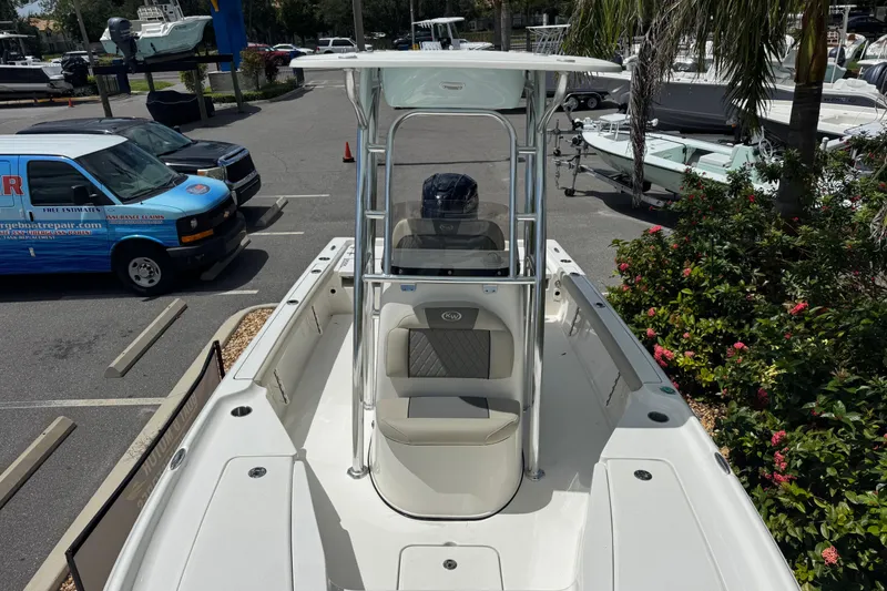 Slide: The Image of 2025 Key West 230 Bay Reef boat in a parking lot, surrounded by greenery and vehicles. - 20