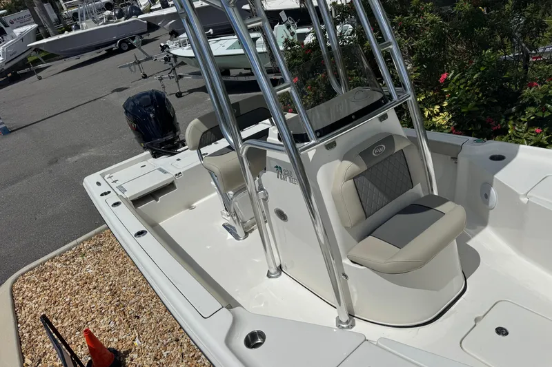 Slide: The Image of 2025 Key West 230 Bay Reef boat interior with seating and console, parked outdoors. - 21
