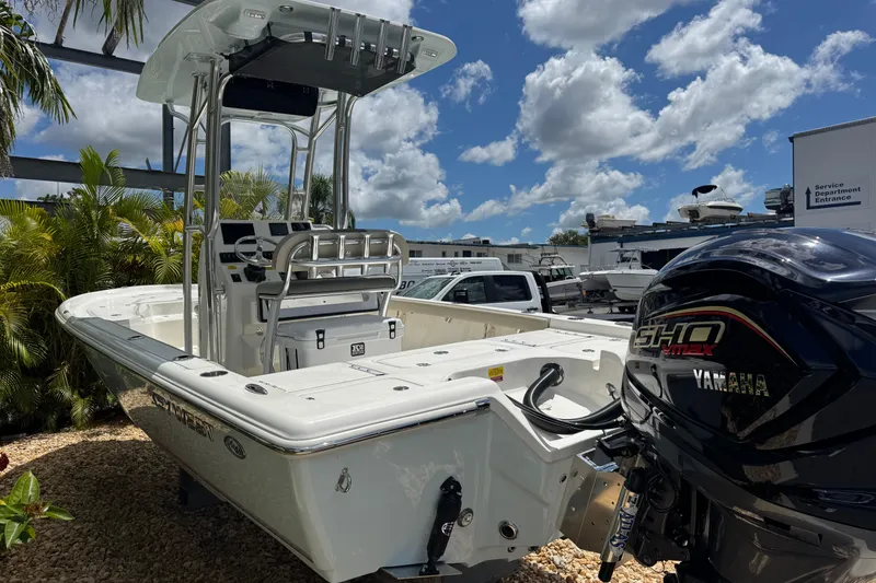 Slide: The Image of 2025 Key West 230 Bay Reef boat with Yamaha engine, parked outdoors under a blue sky. - 5