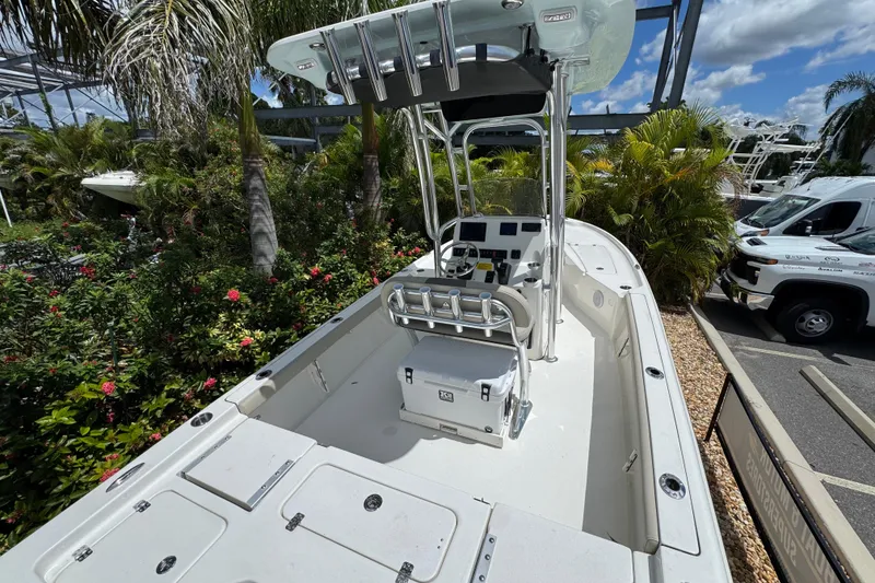 Slide: The Image of 2025 Key West 230 Bay Reef boat, sleek design, surrounded by lush greenery. - 6