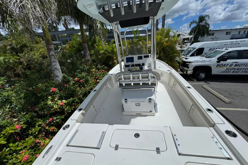 Slide: The Image of 2025 Key West 230 Bay Reef boat, spacious deck, surrounded by lush greenery. - 7