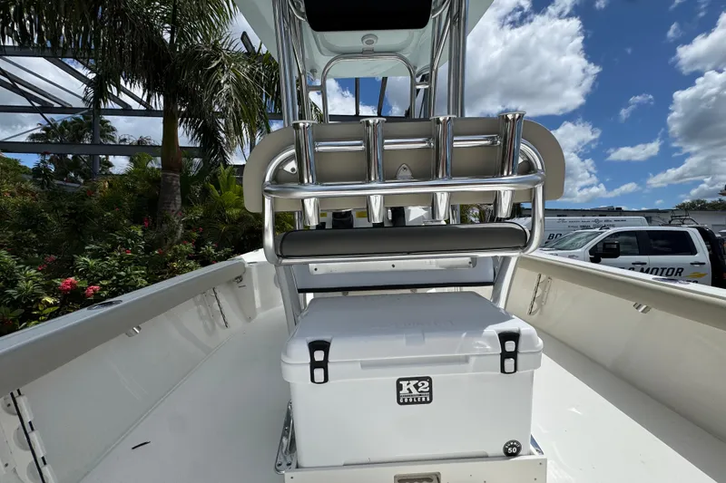 Slide: The Image of 2025 Key West 230 Bay Reef boat interior with cooler and rod holders under a sunny sky. - 8