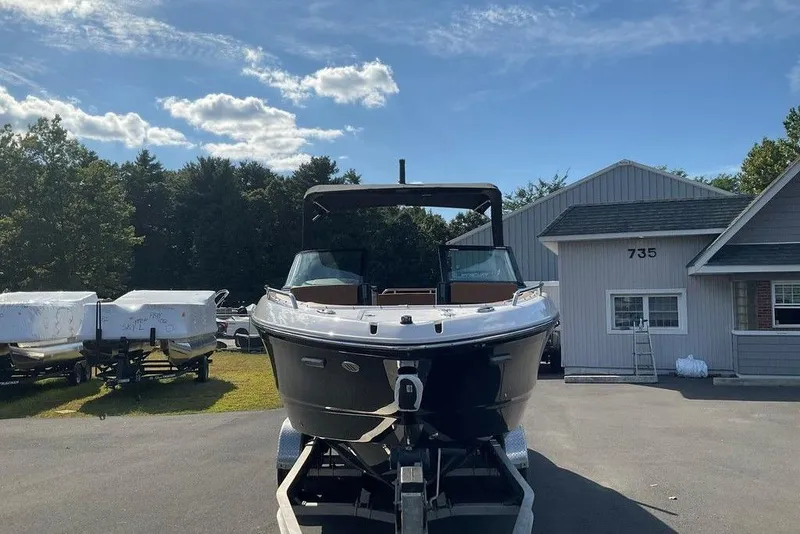 Slide: The Image of 2026 Chaparral SSX 276 boat on trailer, parked outside a building under a clear sky. - 14
