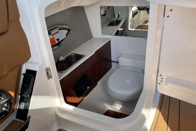 Slide: The Image of Interior of 2026 Chaparral SSX 276 boat featuring a compact bathroom with sink and toilet. - 25