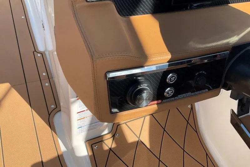 Slide: The Image of 2026 Chaparral SSX 276 boat dashboard with tan upholstery and audio controls. - 28