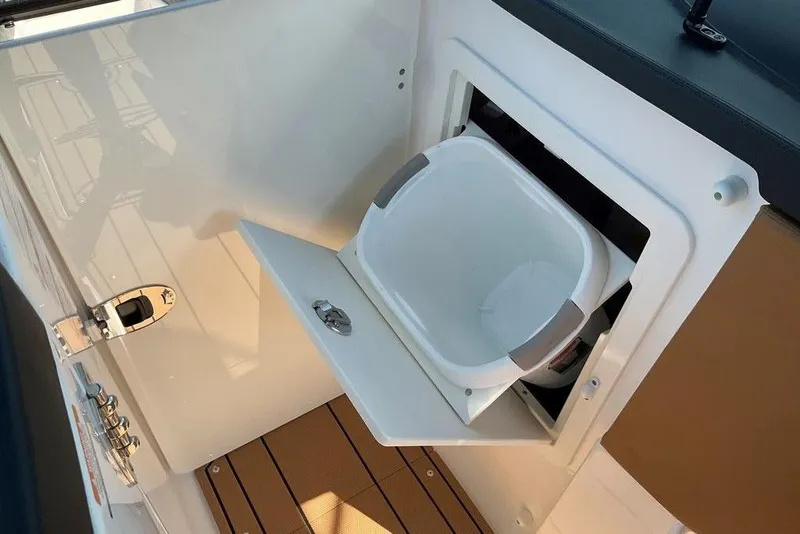 Slide: The Image of 2026 Chaparral SSX 276 boat interior with built-in storage compartment and white bucket. - 35