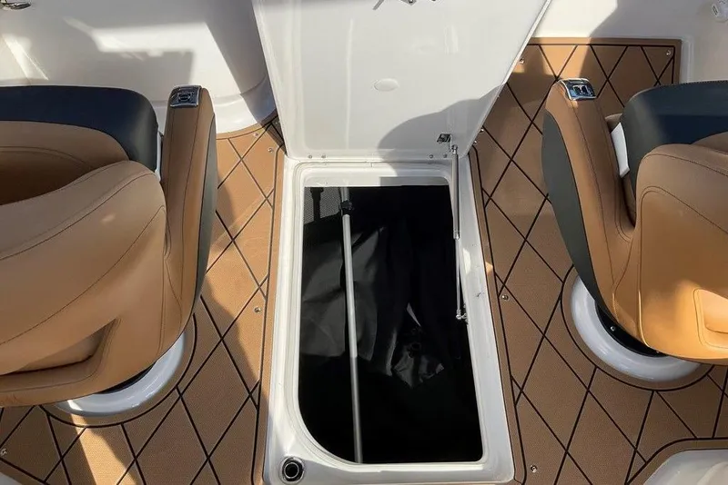 Slide: The Image of 2026 Chaparral SSX 276 boat interior with open storage compartment and tan seating. - 50