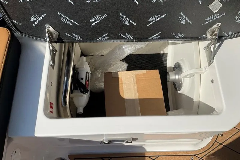 Slide: The Image of Open storage compartment in 2026 Chaparral SSX 276 boat with safety equipment and box. - 52