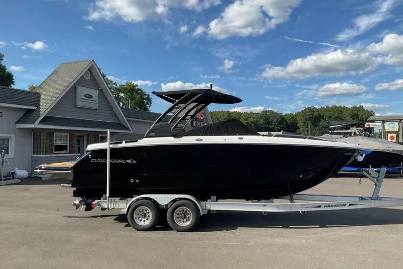 Slide: The Image of 2026 Chaparral SSX 276 boat on trailer, parked outside dealership under blue sky. - 7