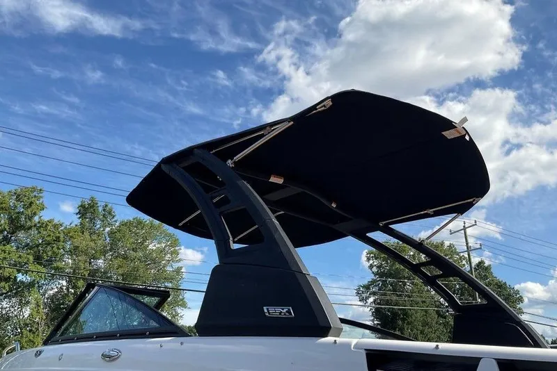 Slide: The Image of 2026 Chaparral SSX 276 boat with sleek black canopy against a blue sky. - 8