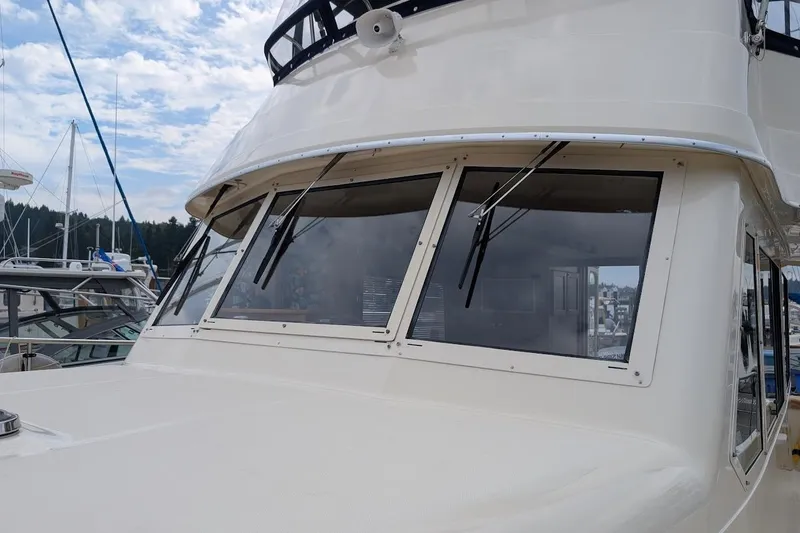 Slide: The Image of 2008 Mainship 38 yacht with sleek windows and wipers, docked at a marina. - 2