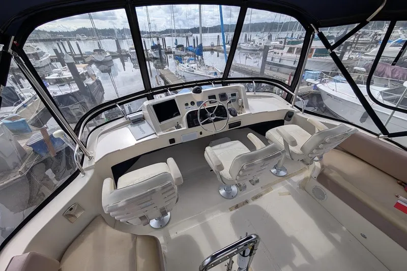 Slide: The Image of 2008 Mainship 38 yacht cockpit with helm, chairs, and marina view. - 23
