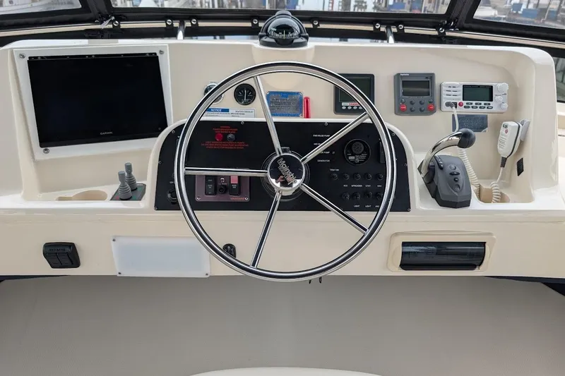 Slide: The Image of Control panel of a 2008 Mainship 38 boat with steering wheel and navigation instruments. - 25