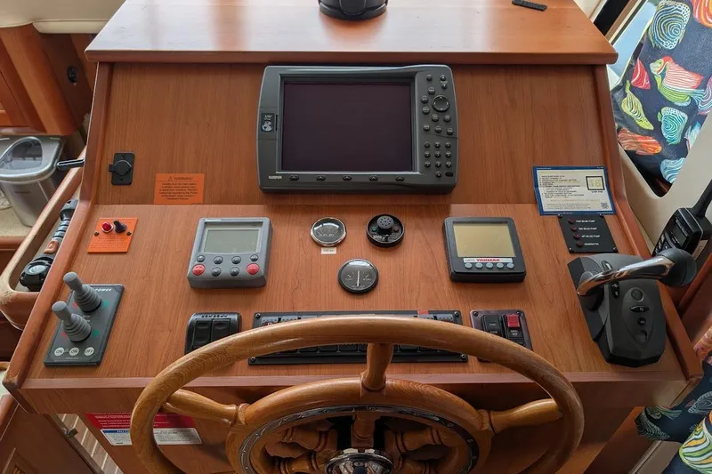 Slide: The Image of 2008 Mainship 38 helm with navigation equipment and wooden steering wheel. - 13